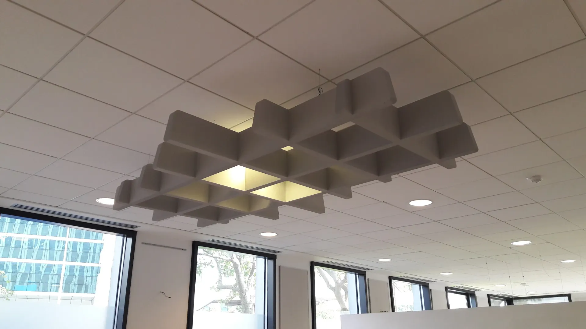 Une pièce avec un plafond sur lequel il y a des carrés. Aménagement de bureaux et locaux professionnels - SPAC