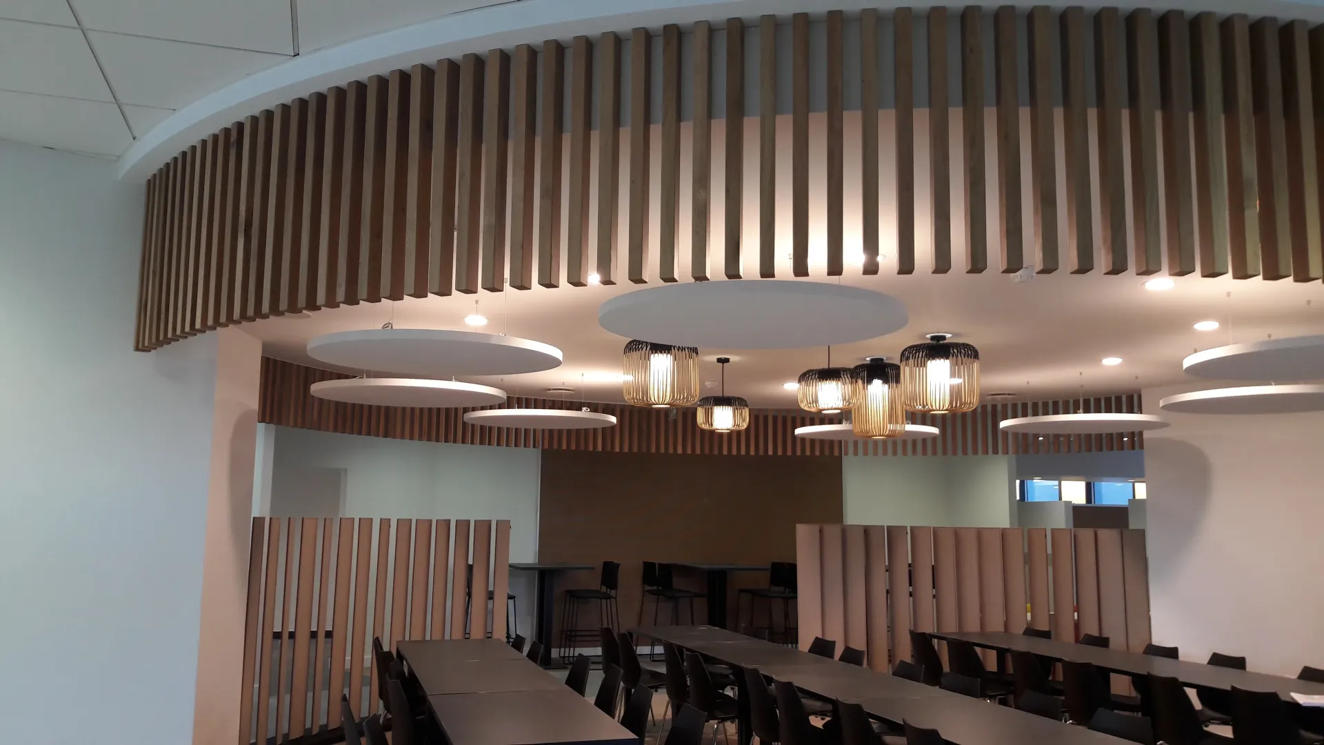 Une salle de conférence avec tables et chaises et un plafond en bois. Aménagement de bureaux et locaux professionnels - SPAC