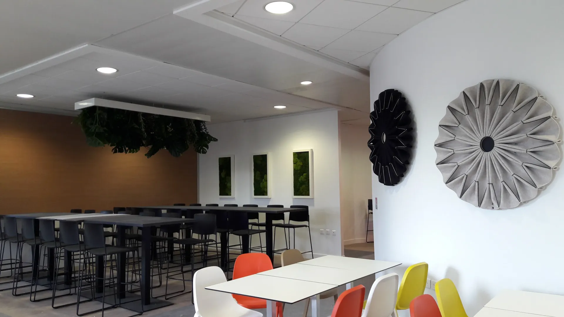 Une pièce avec des tables et des chaises et une horloge sur le mur. Aménagement de bureaux et locaux professionnels - SPAC