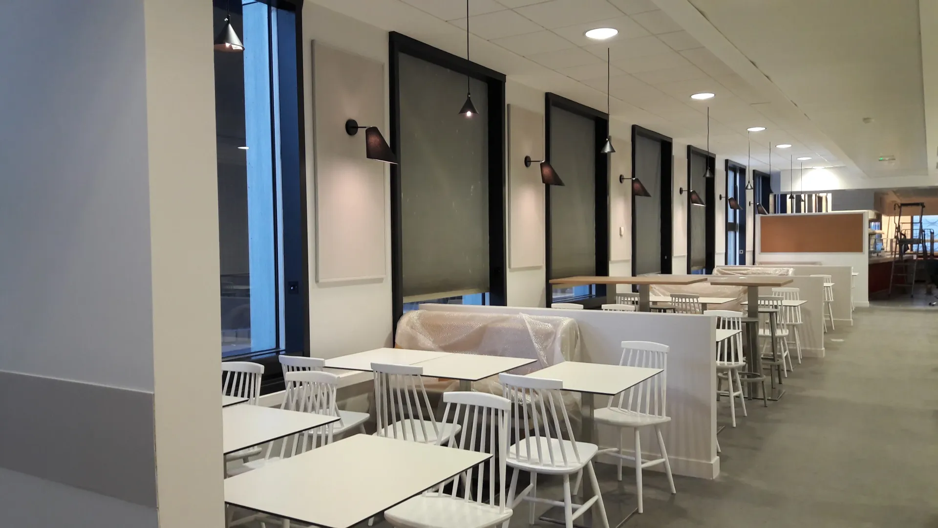 Une longue rangée de tables et de chaises dans un restaurant. Aménagement de bureaux et locaux professionnels - SPAC