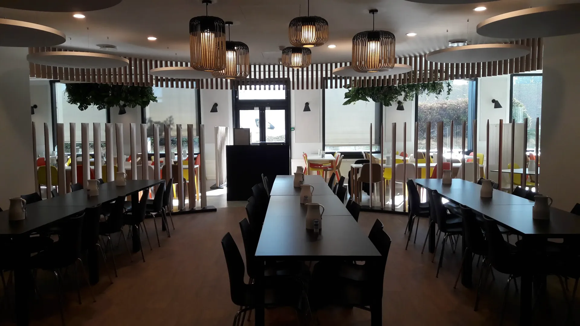 Une grande salle avec des tables et des chaises dans un restaurant. Aménagement de bureaux et locaux professionnels - SPAC