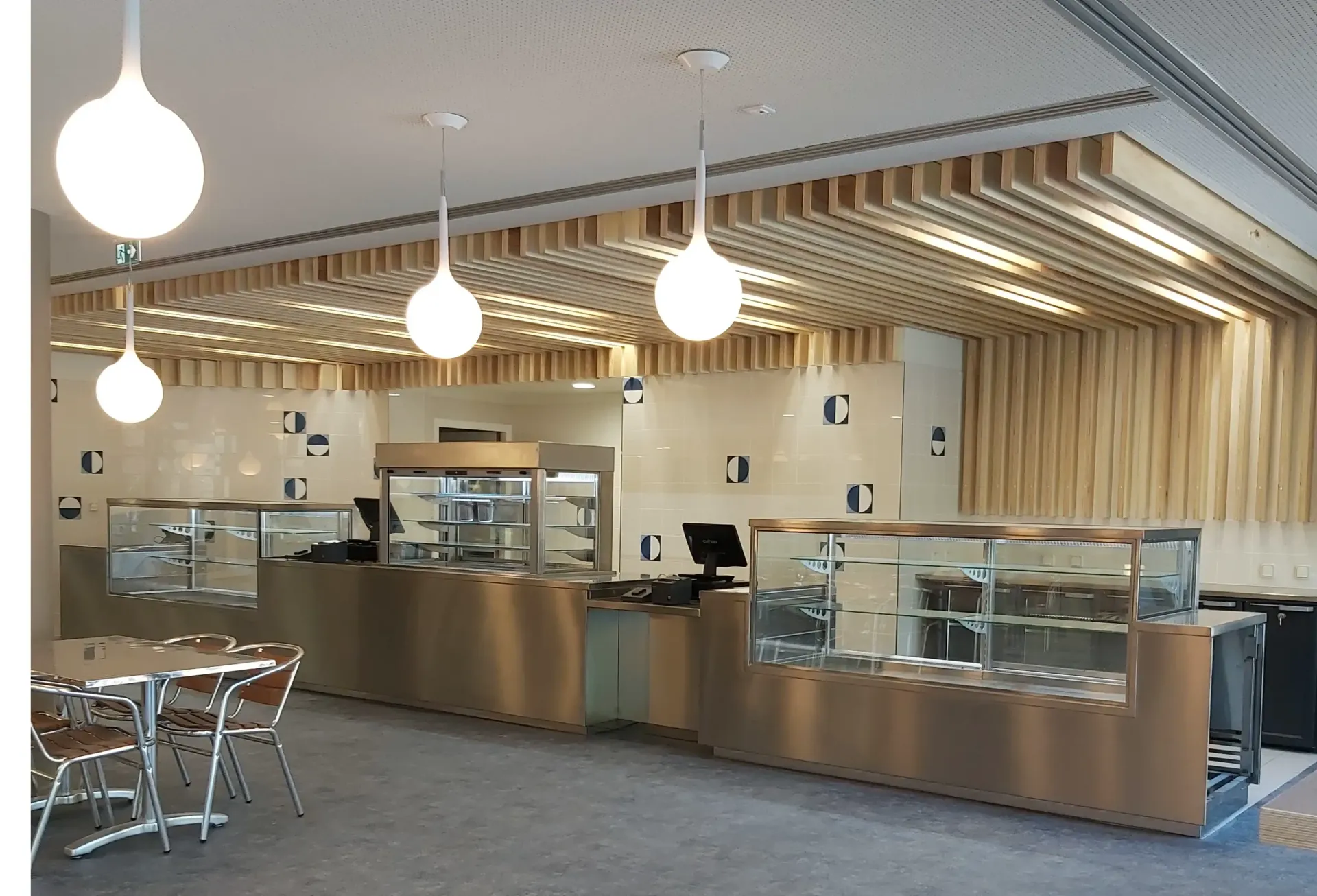 Un restaurant avec des tables et des chaises et un ordinateur sur le comptoir. Aménagement de bureaux - SPAC