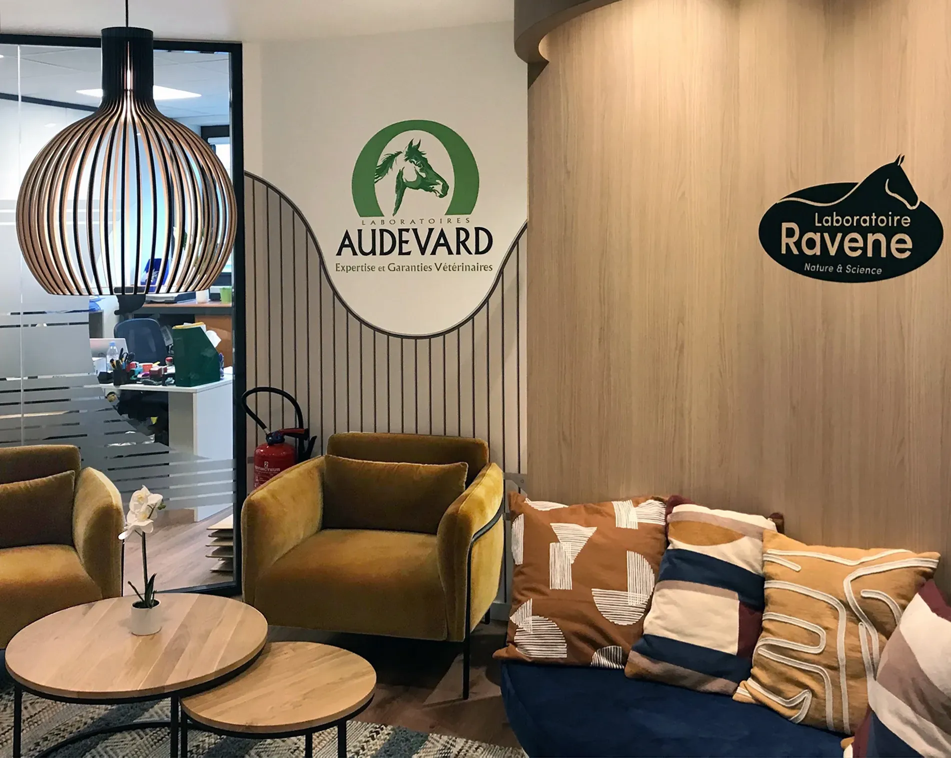 Un salon avec un canapé, des chaises, des tables et un panneau sur le mur. Aménagement SPAC