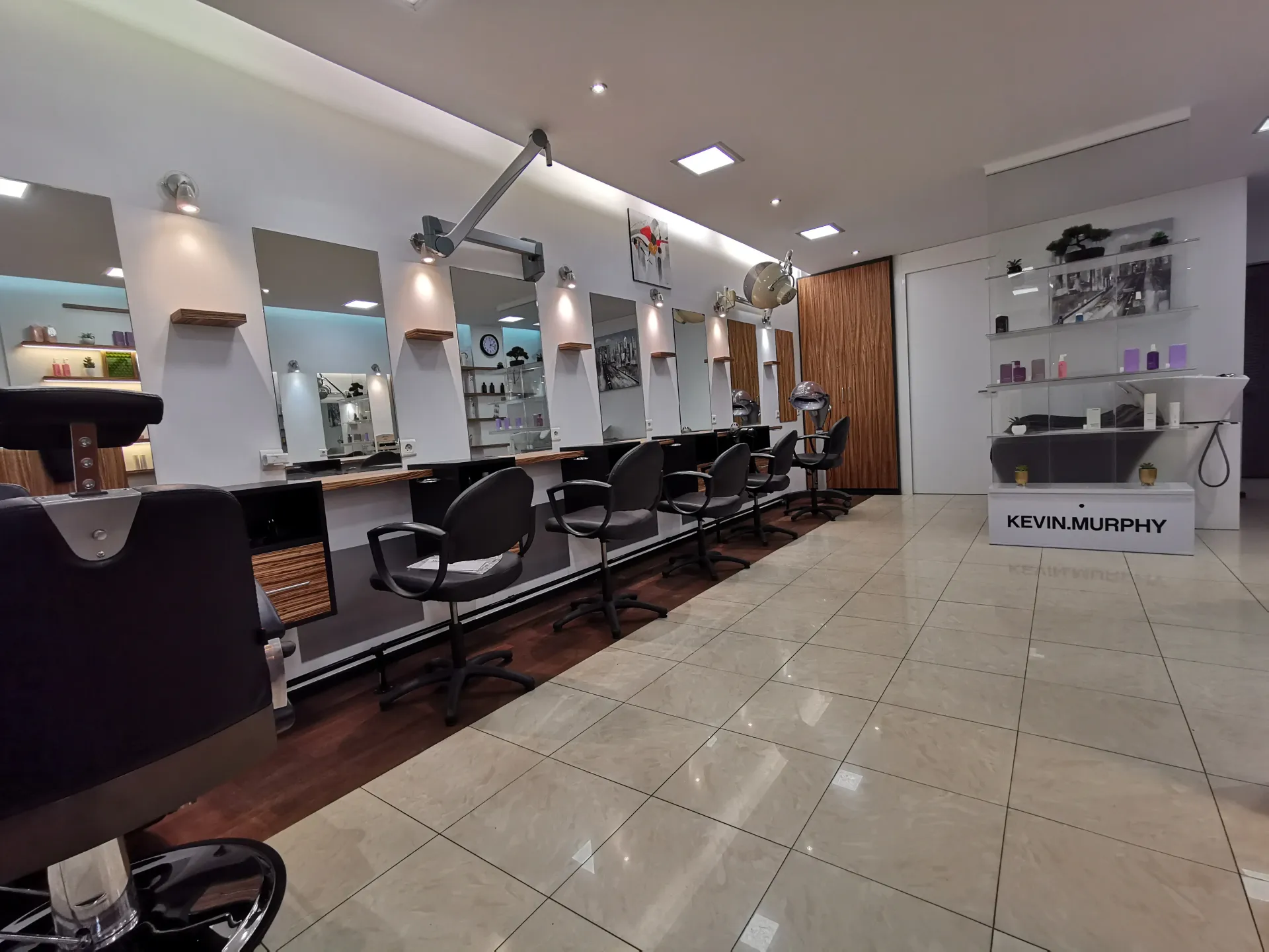 Un salon de coiffure avec beaucoup de chaises et de miroirs. Aménagement de bureaux et locaux professionnels - SPAC