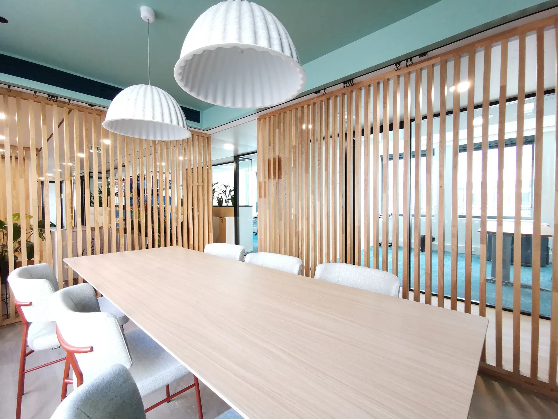 Une salle de conférence avec une longue table en bois et des chaises. Aménagement de bureaux et locaux professionnels - SPAC