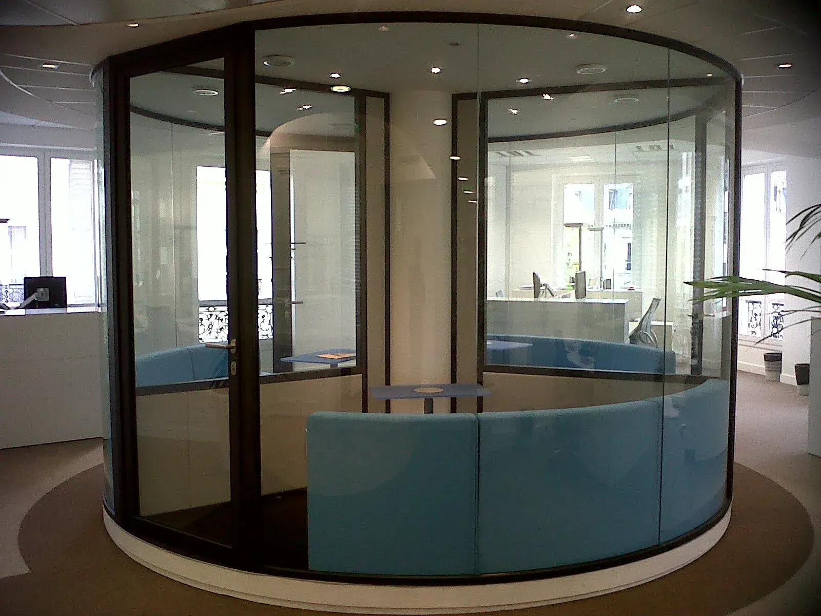 Une pièce ronde avec un canapé bleu dedans. Aménagement de bureaux et locaux professionnels - SPAC