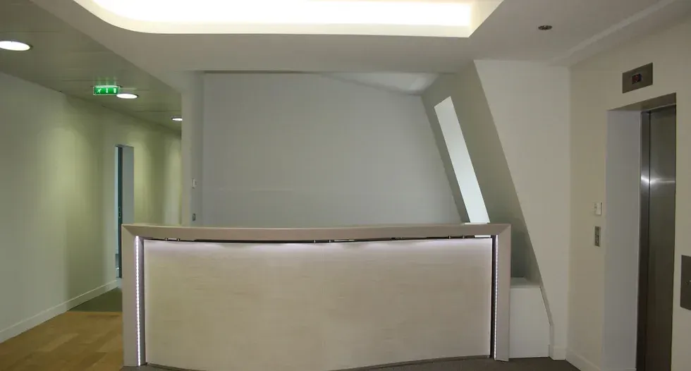 Un bureau de réception dans un couloir à côté d'un ascenseur. Aménagement de bureaux et locaux professionnels - SPAC