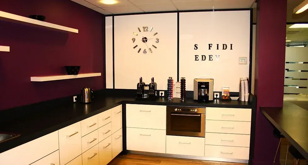 Une cuisine avec une horloge sur le mur qui dit « a fide koe ». Aménagement de bureaux et locaux professionnels - SPAC