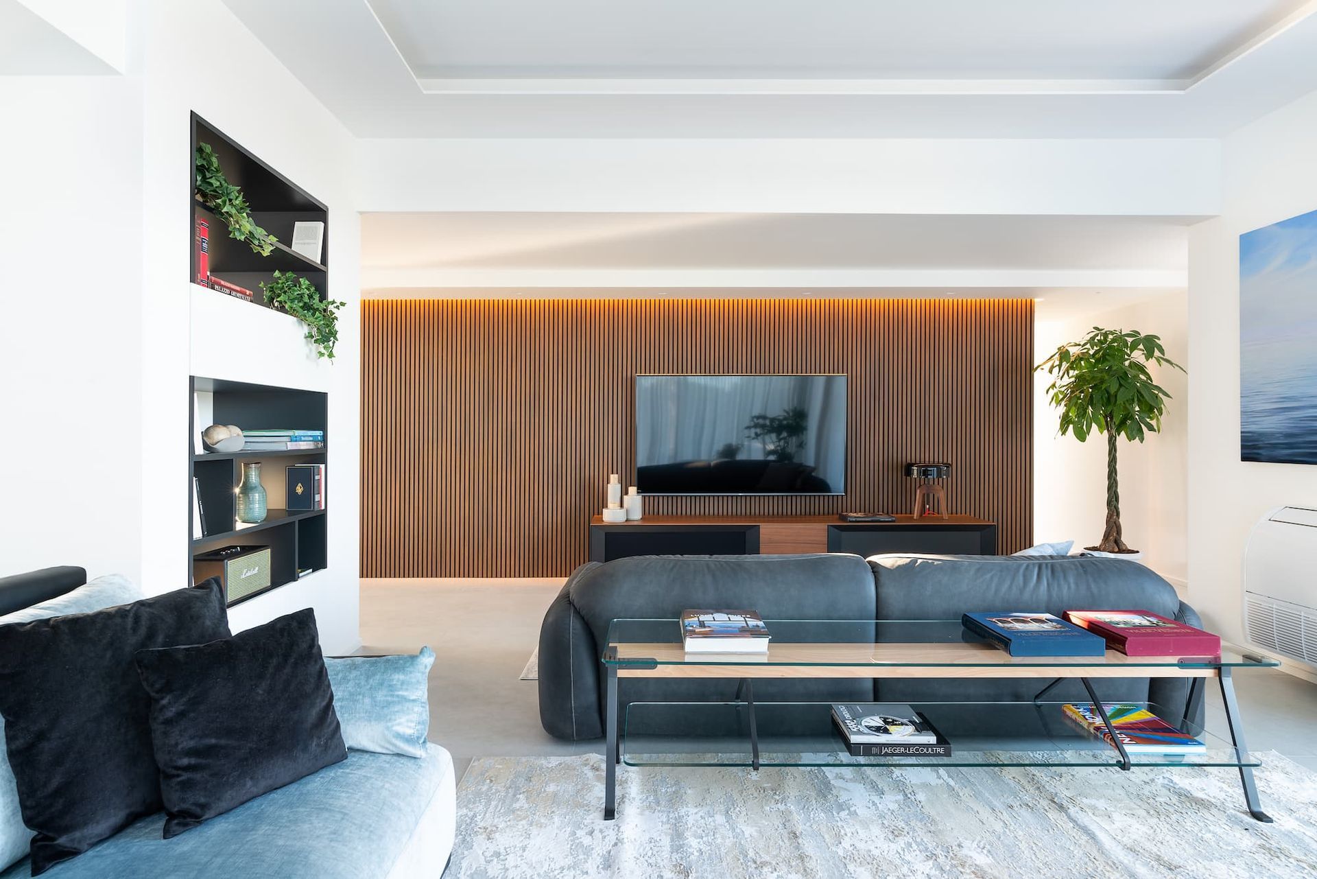 Een woonkamer met een bank, tafel en televisie.