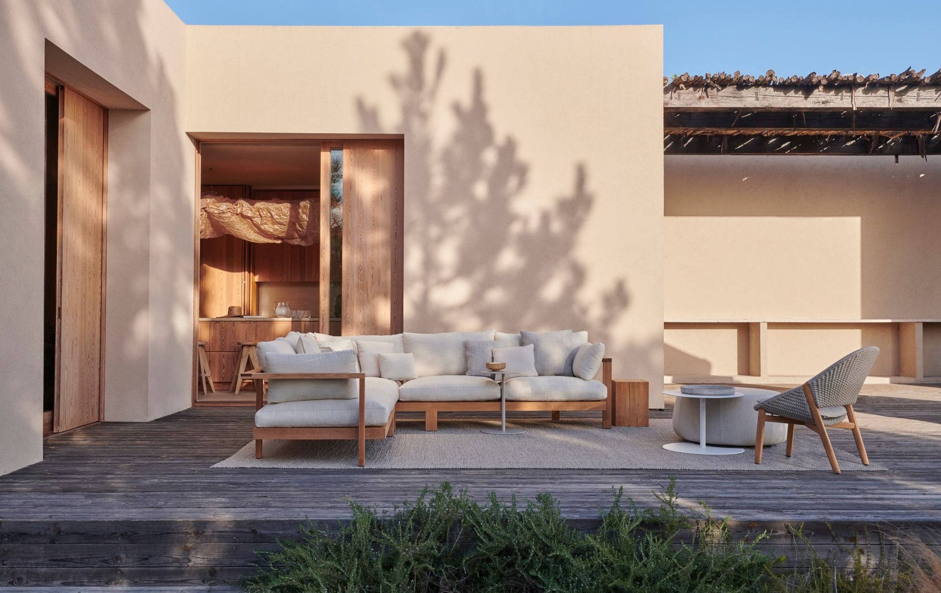 Een terras met een bank en stoelen voor een huis.