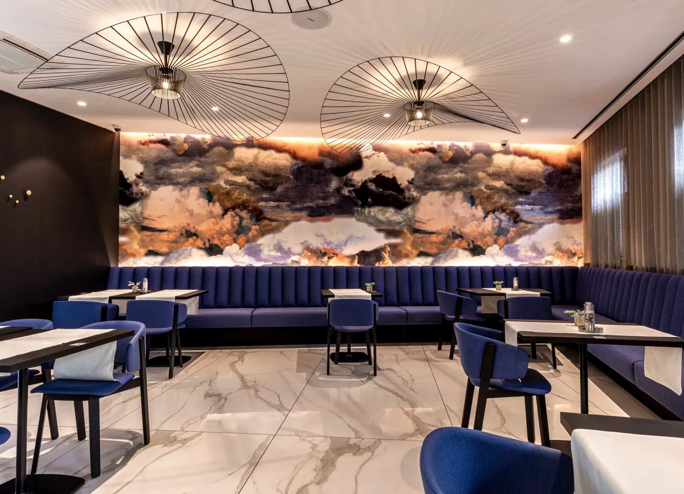Een restaurant met tafels en stoelen en een schilderij aan de muur.