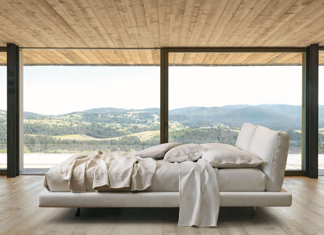 Een bed in een slaapkamer met uitzicht op de bergen.