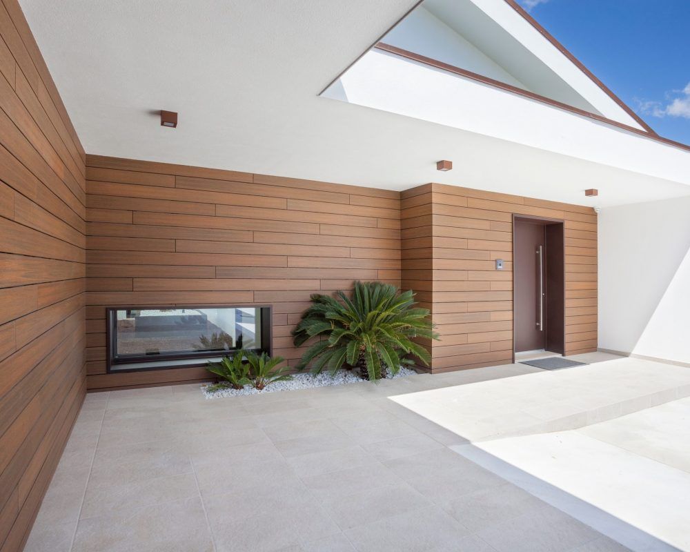 Een modern huis met houten lambrisering en een groot raam
