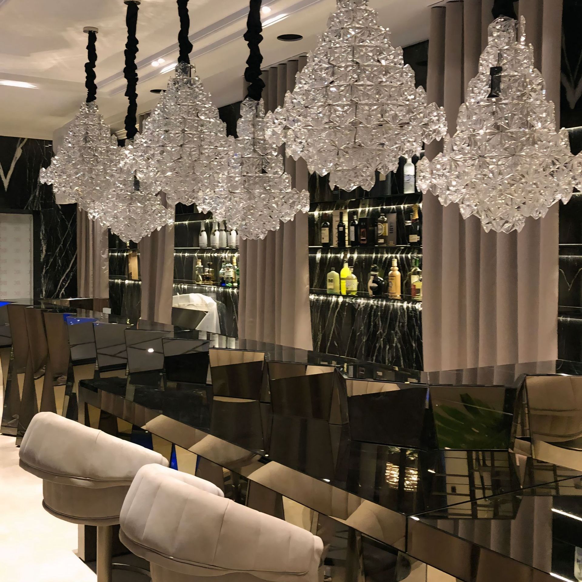Een bar met veel kristallen kroonluchters aan het plafond
