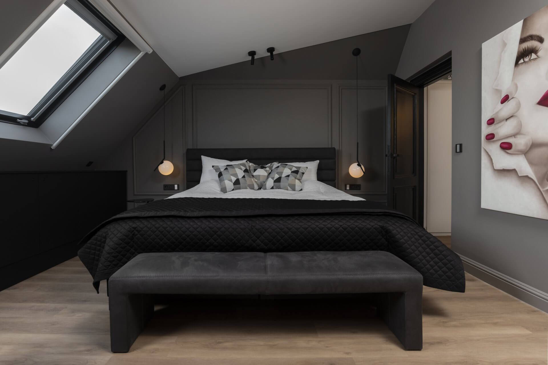 Er hangt een foto van een vrouw aan de muur boven het bed.