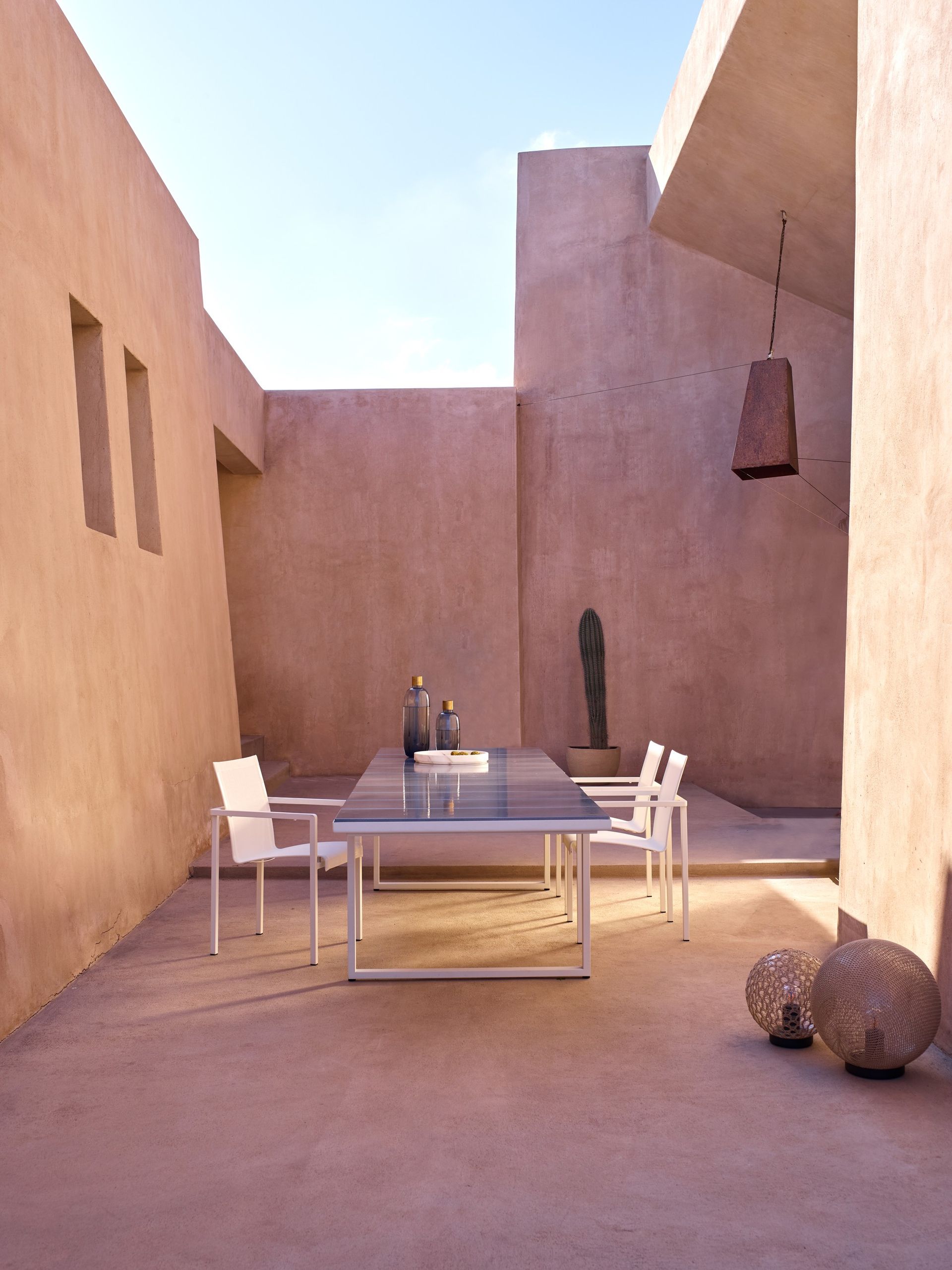 Een terras met een tafel en stoelen voor een gebouw