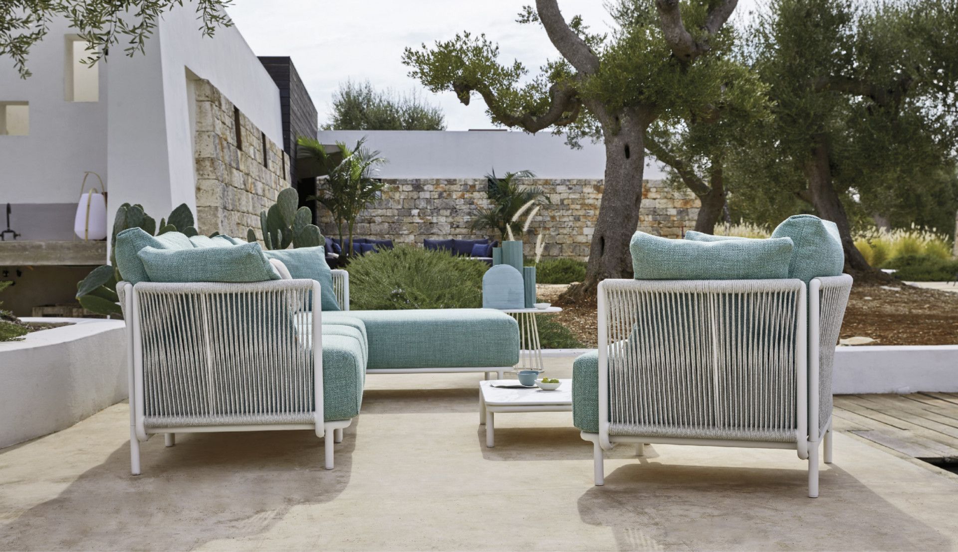 Een terras met twee stoelen en een tafel voor een huis