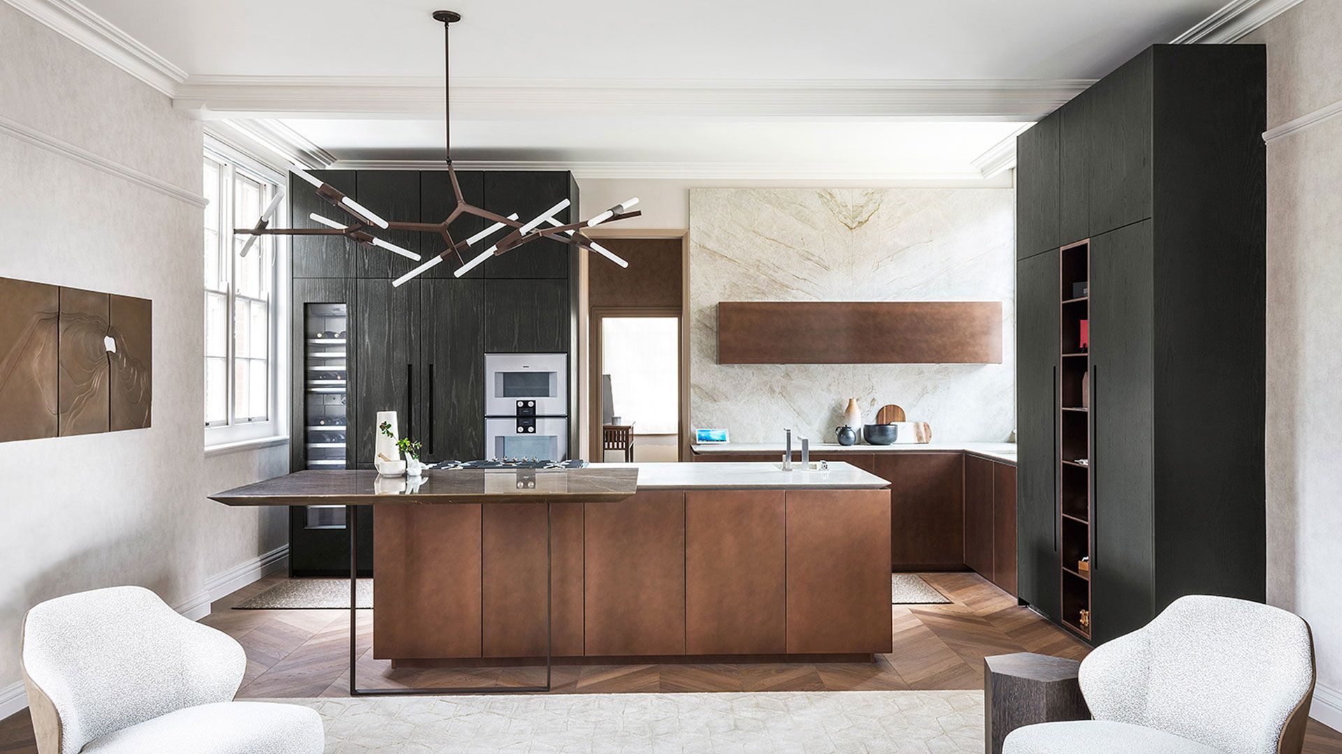 Een keuken met een groot houten eiland en twee stoelen