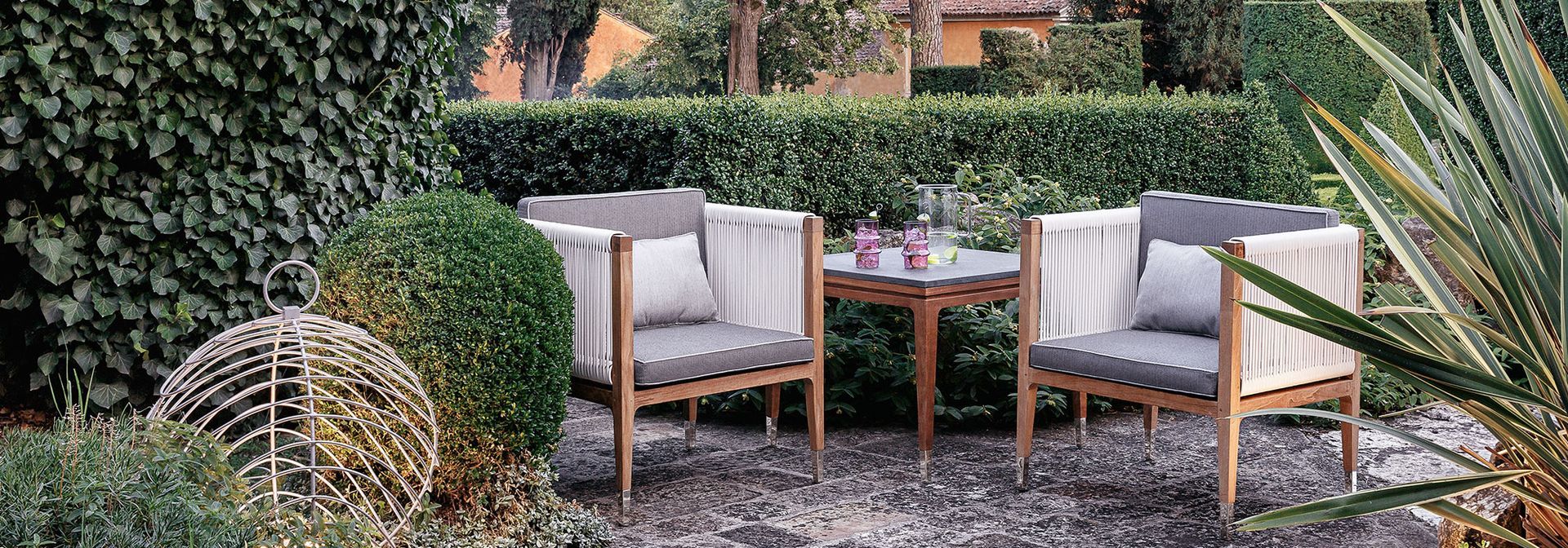 Er staan ​​twee stoelen en een tafel in de tuin.