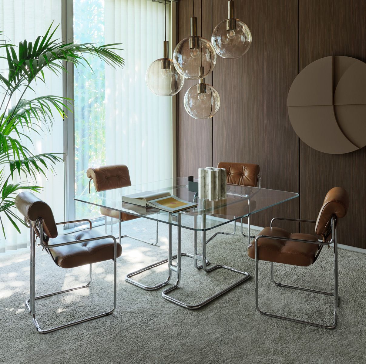 Een eetkamer met een glazen tafel en stoelen