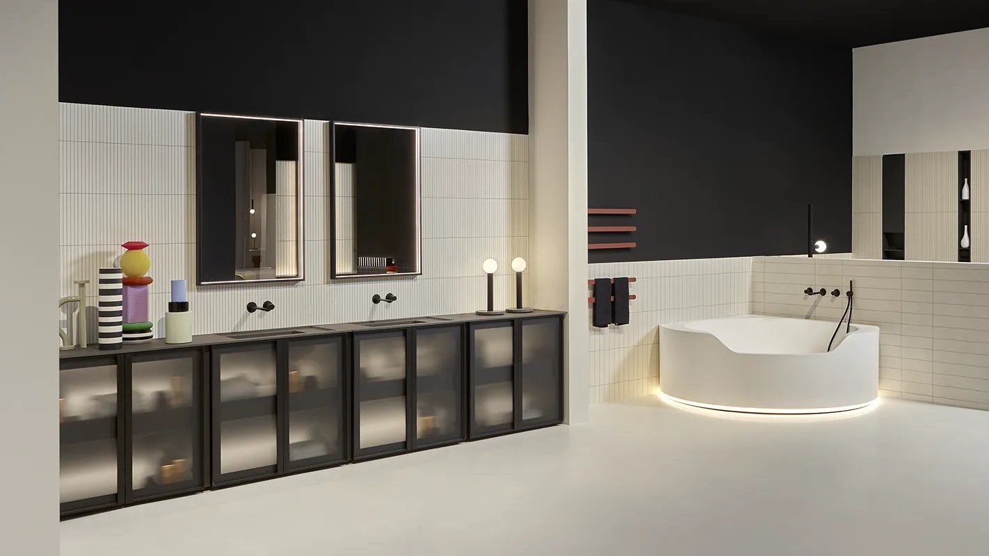 Een badkamer met een bad, wastafel en spiegels