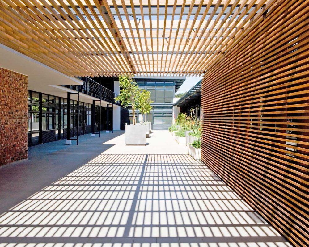 Een houten pergola bedekt een binnenplaats in een gebouw.