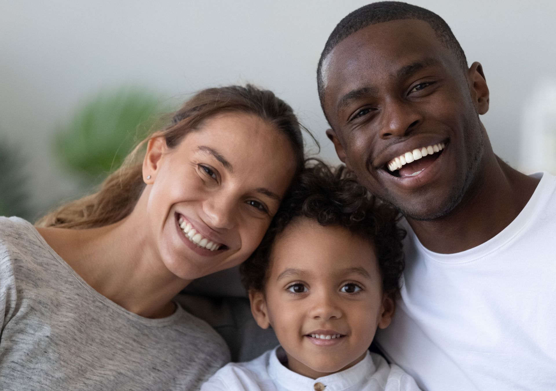A family is sitting on a blanket on the beach.