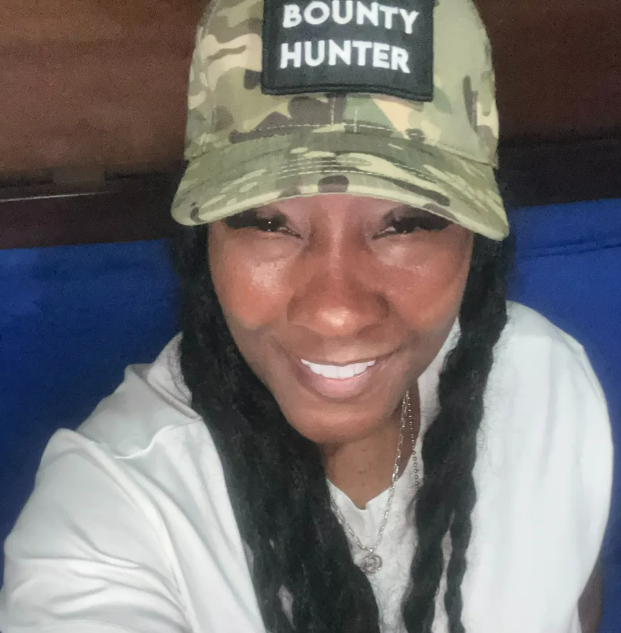 A woman wearing a hat that says bounty hunter