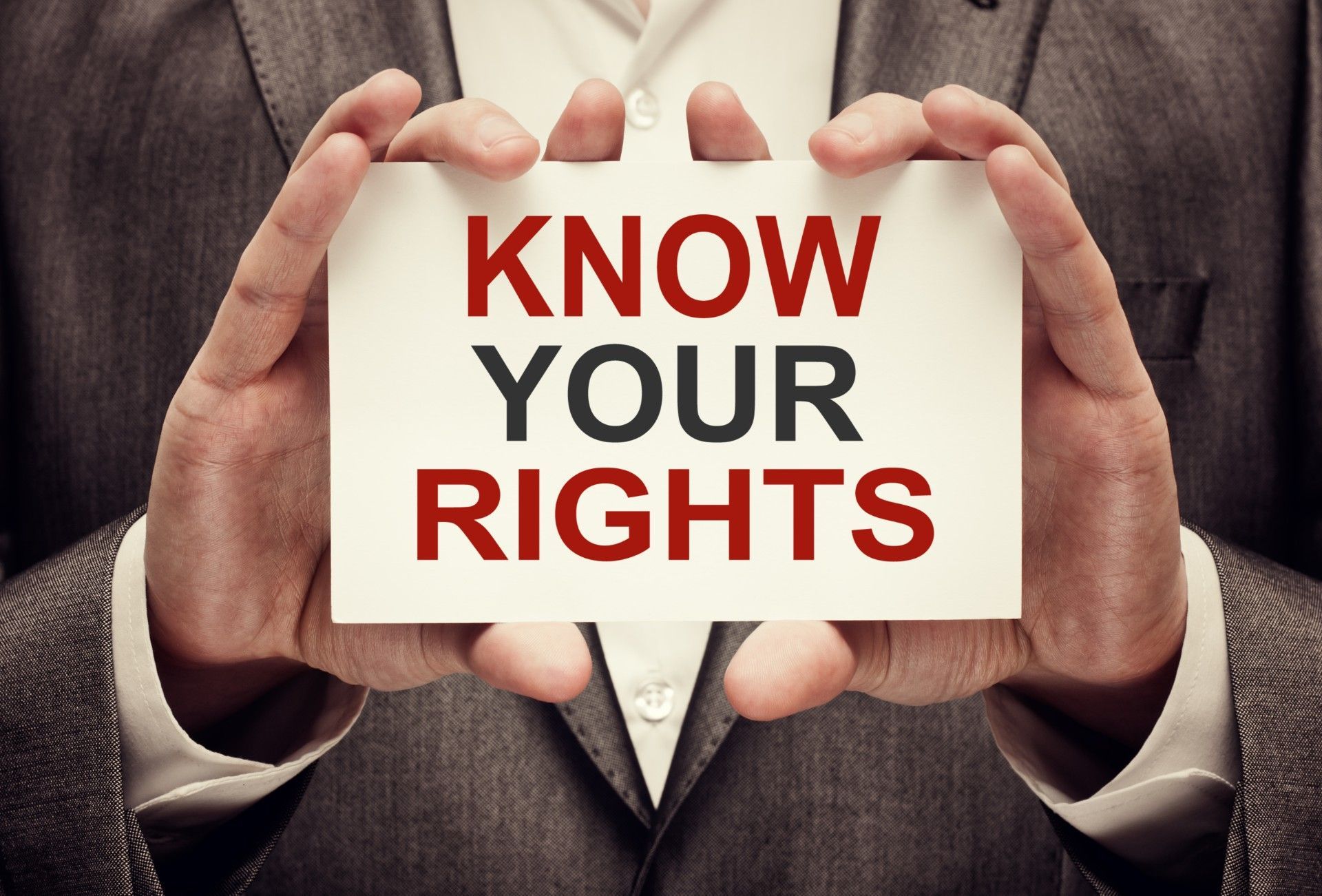 A person is signing a document on a clipboard with a pen.