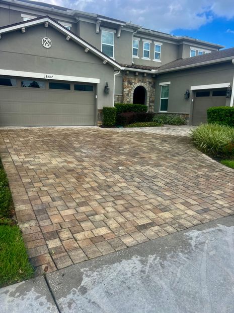 A large house with a brick driveway in front of it