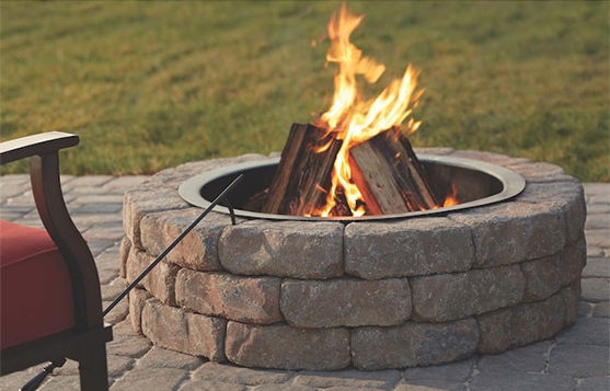 A fire pit with a chair sitting next to it