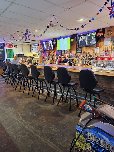 A bar with a lot of chairs and a motorcycle parked in front of it.