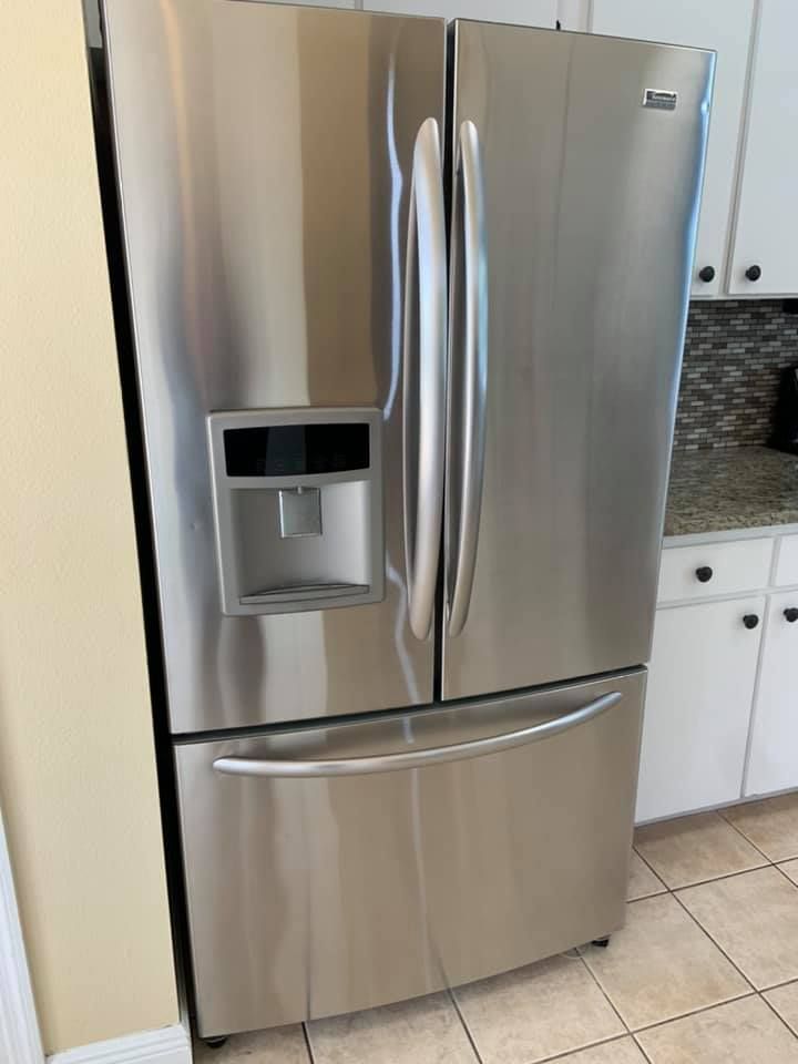 An interior view of a commercial ice machine with a bin full of clear, cube-shaped ice.