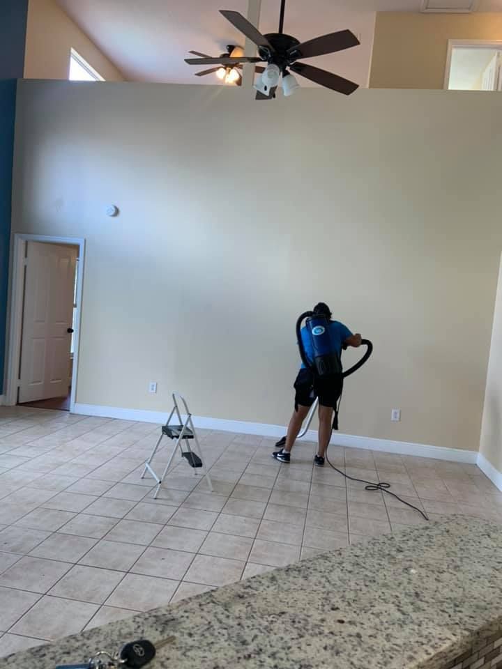 A bright blue gas flame burns from a metallic U-shaped burner inside a metal fire pit enclosure.