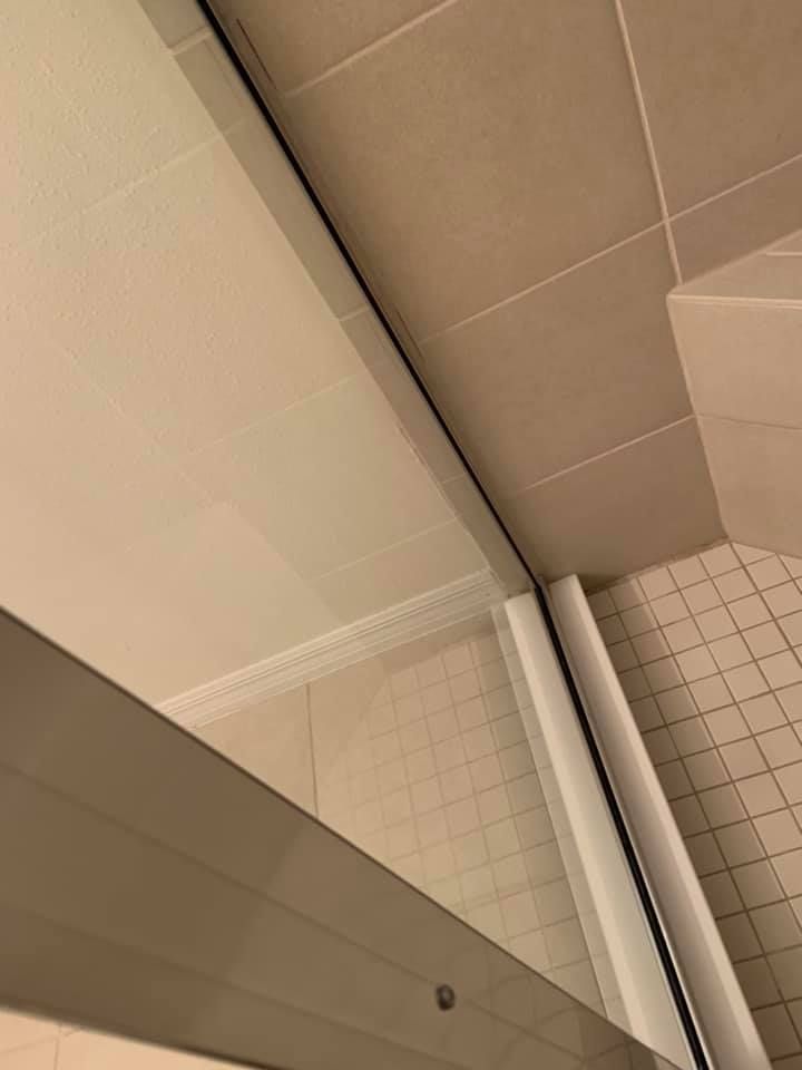 A modern kitchen features white cabinets, granite countertops, a stainless steel microwave and stove, and double windows.