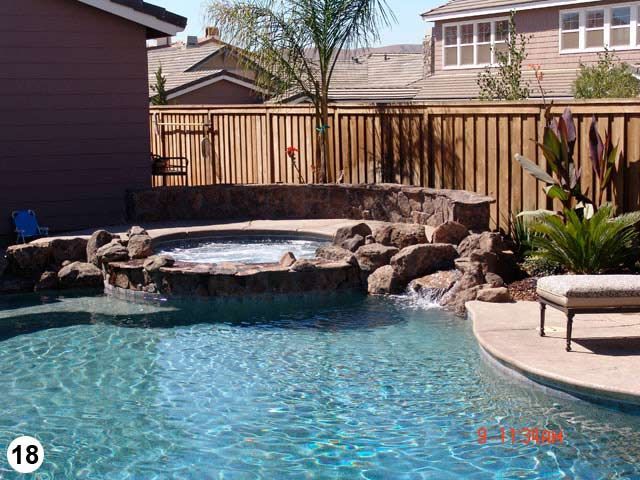 A large swimming pool with a wooden fence surrounding it