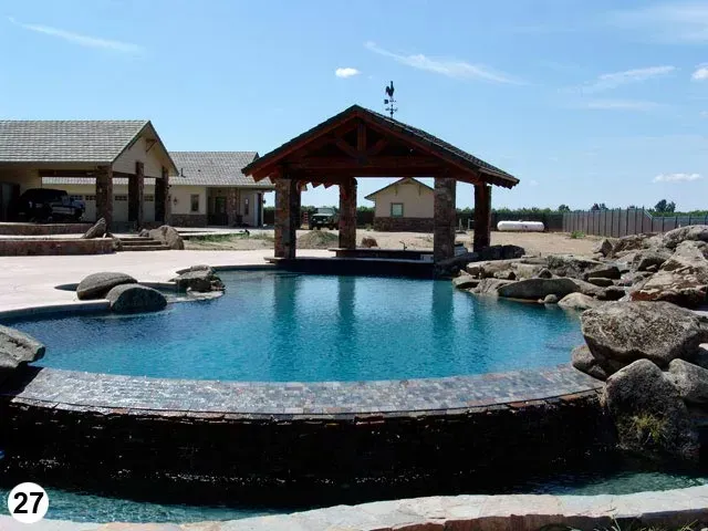 A large swimming pool with a gazebo in the background