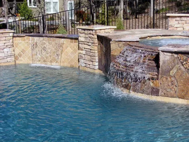 There is a waterfall in the middle of the pool.