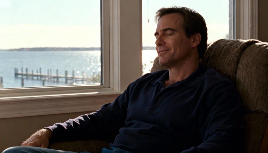 A man sitting comfortably on a sofa overlooking the Chesapeake Bay, peaceful expression on his face