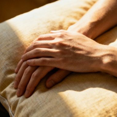 Close-up of relaxed hands resting on a pillow, symbolizing relief from chronic pain
