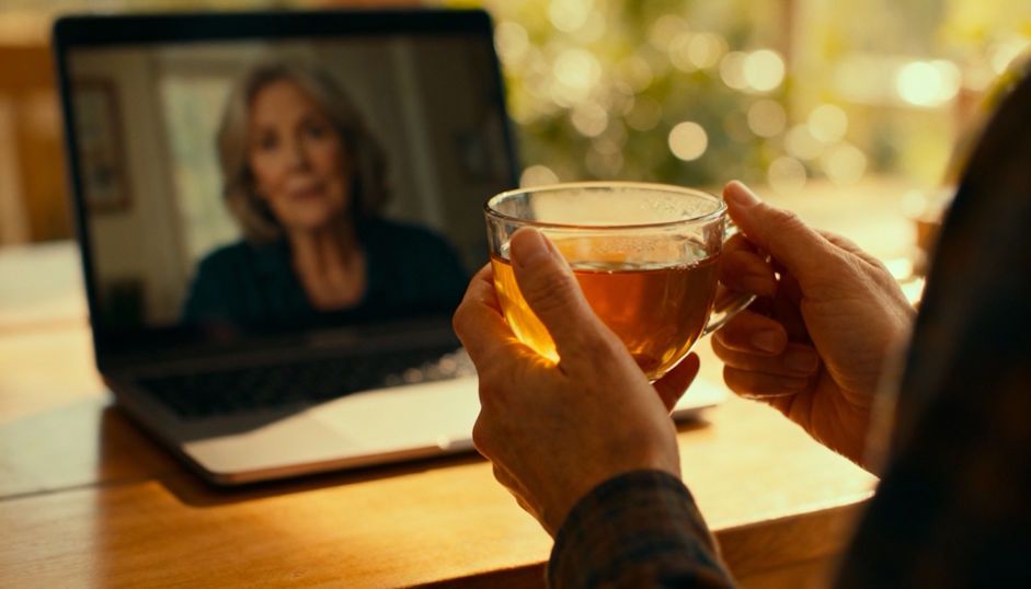 close-up of hands holding a warm cup of tea for a virtual hypnosis session with a middle-aged woman 