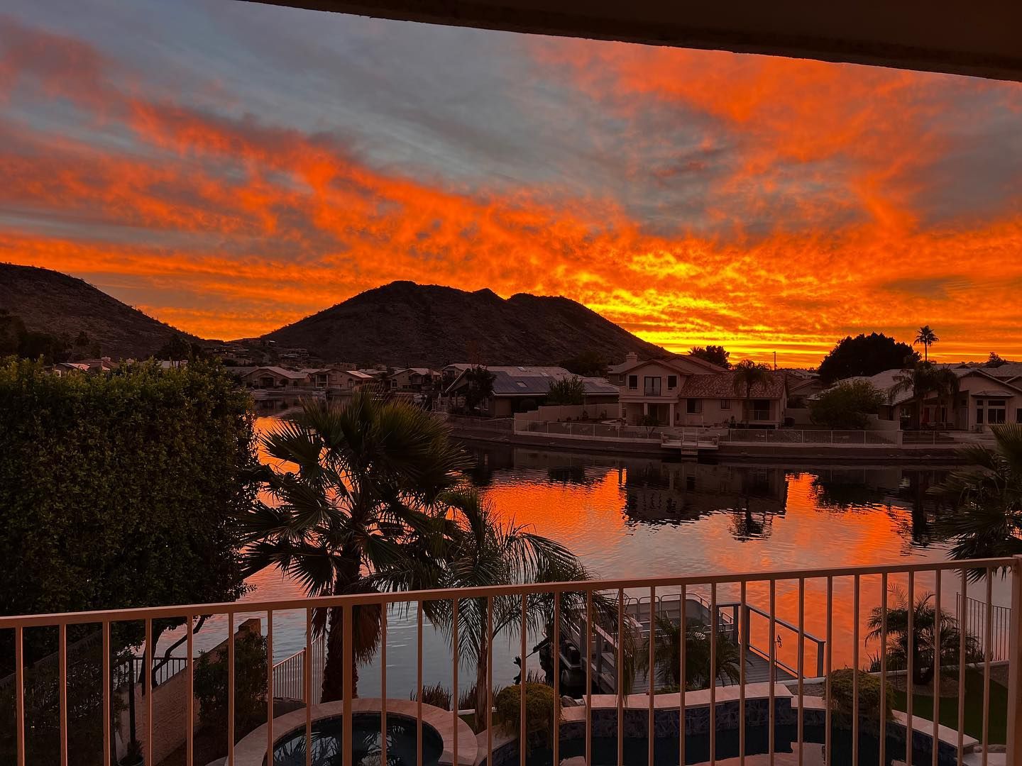 A sunset over a body of water with mountains in the background