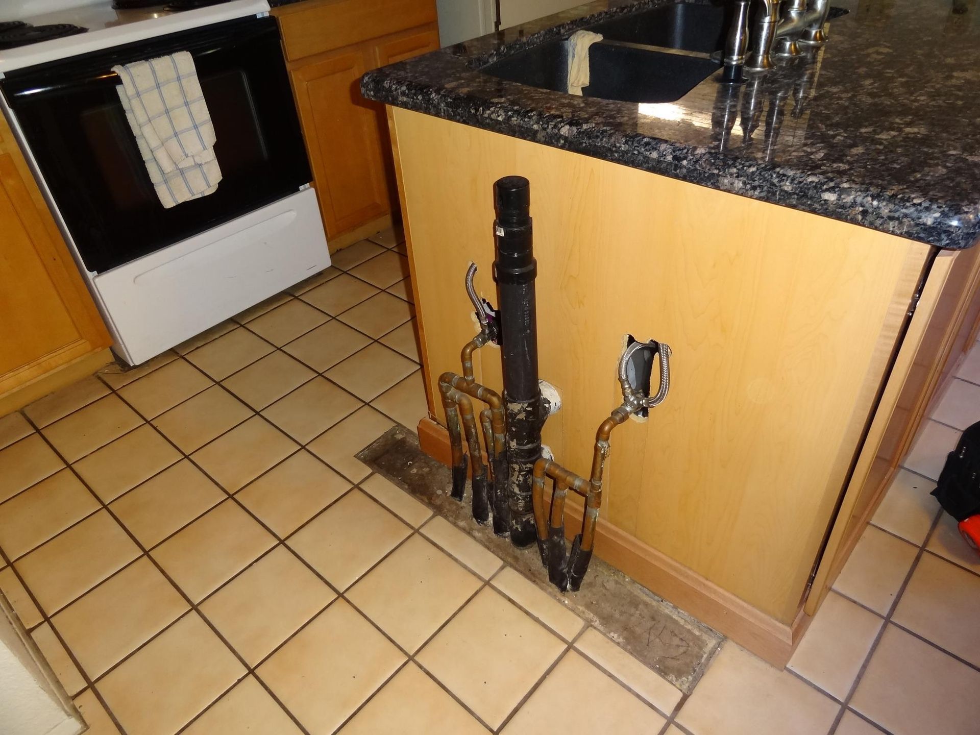 A kitchen with a sink and a stove with a towel on it