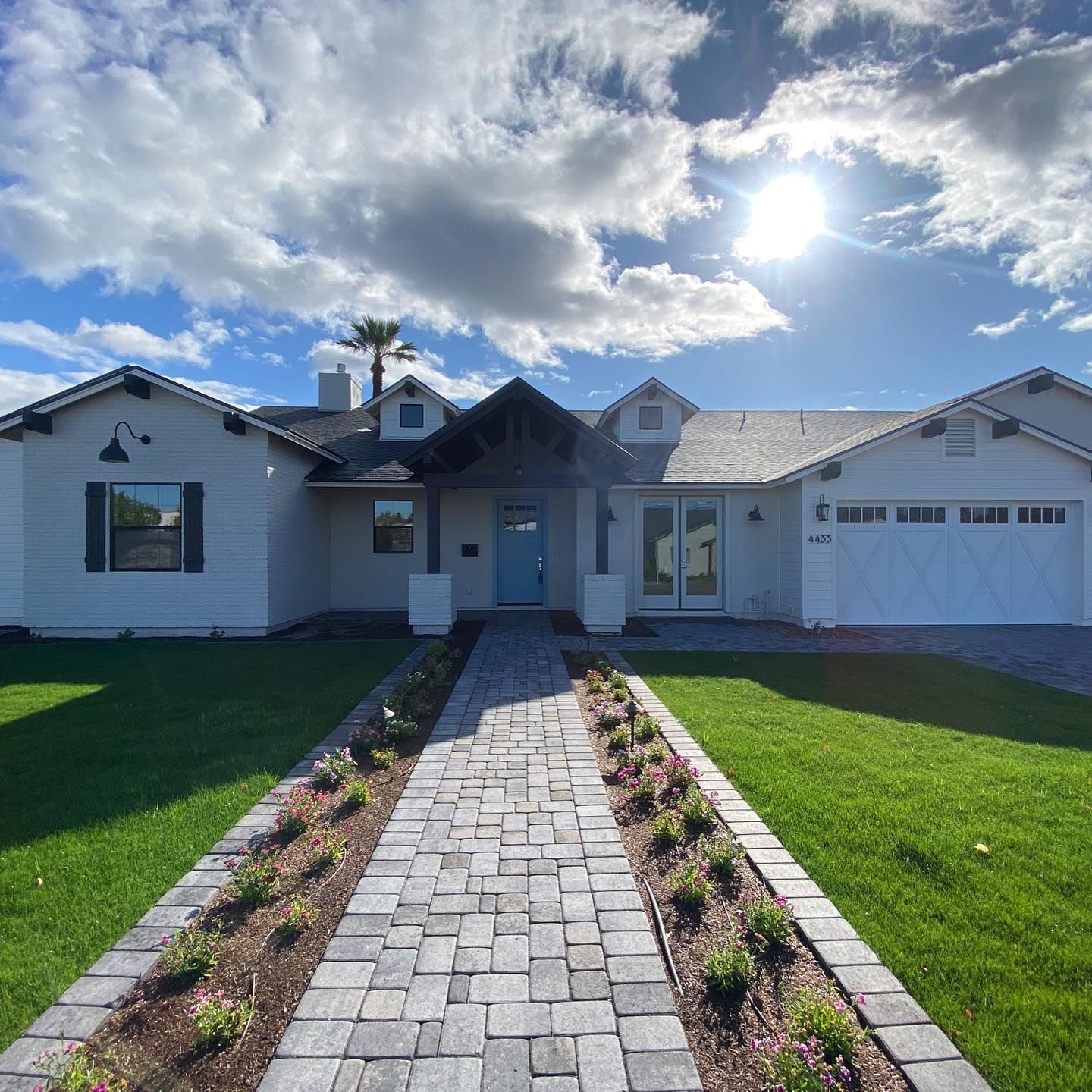A white house with a brick walkway leading to it