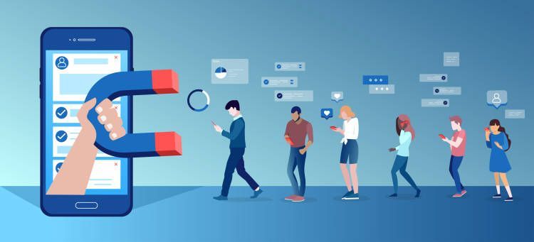 A hand is holding a magnet in front of a cell phone.