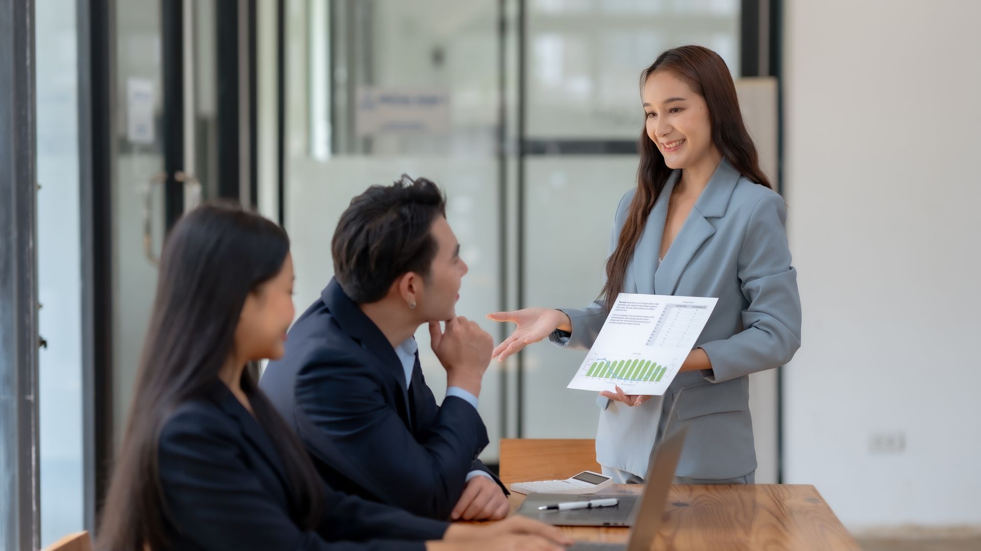 A woman is giving a presentation to a group of business people.