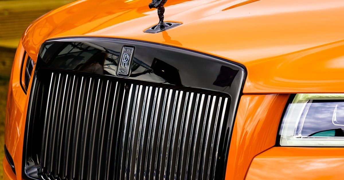 A close up of the front of an orange car with a black grill.