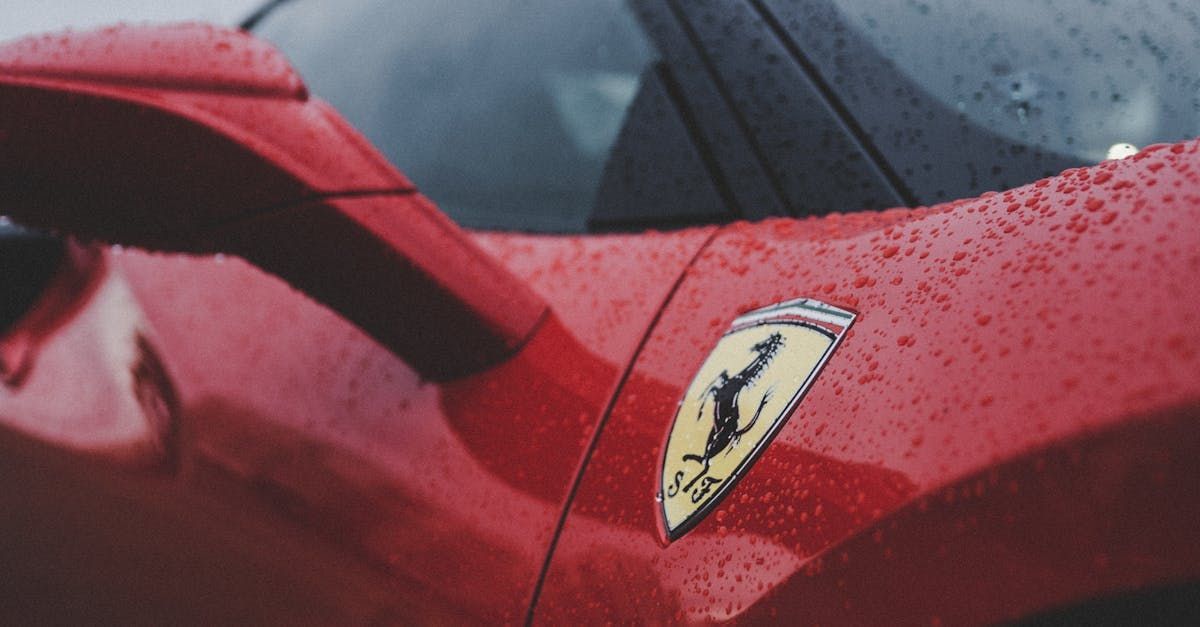 A red ferrari sports car is parked in the rain.