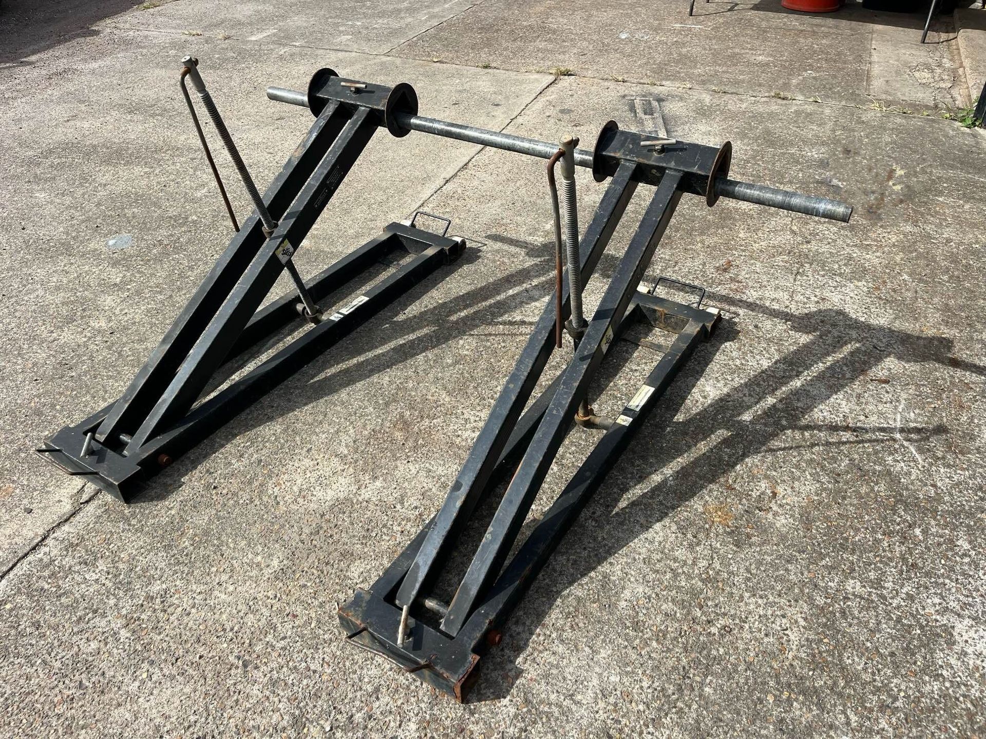 A pair of scissor lifts are sitting on a concrete surface.