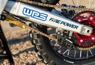 Close-up of a dirt bike's rear wheel, chain, and swingarm with 